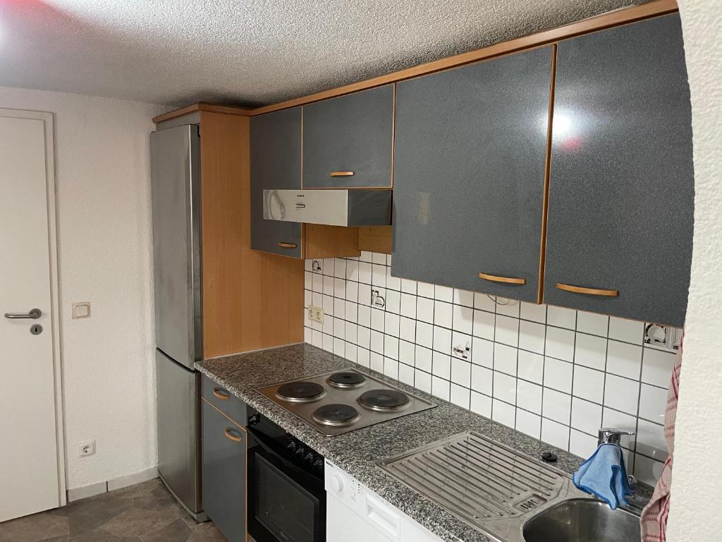 a kitchen with gray cabinets and a stove top oven at Haus Dambacher - Arbeiter-Monteurzimmer in Nürtingen