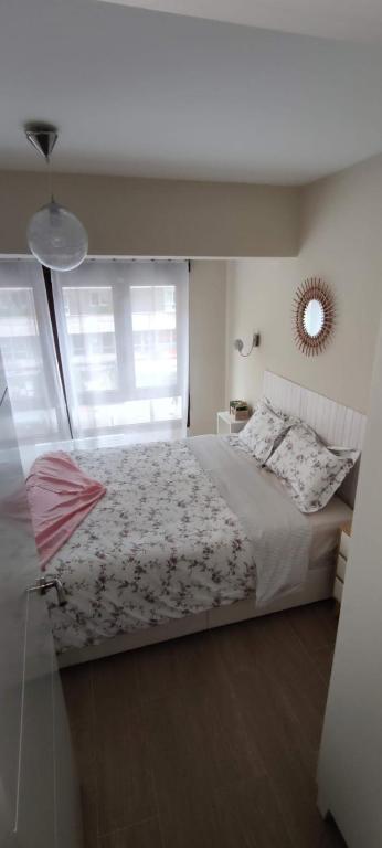 a bedroom with a bed with a window and a mirror at Parque Playa II in Gijón
