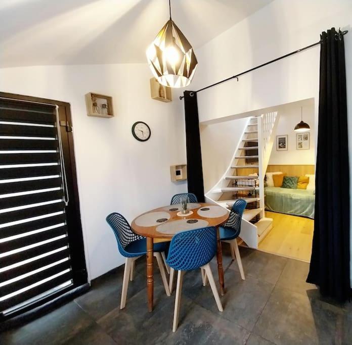 une salle à manger avec une table et des chaises et un escalier dans l'établissement Appartement Cosy Ploumanac'h classé 2 étoiles, à Perros-Guirec
