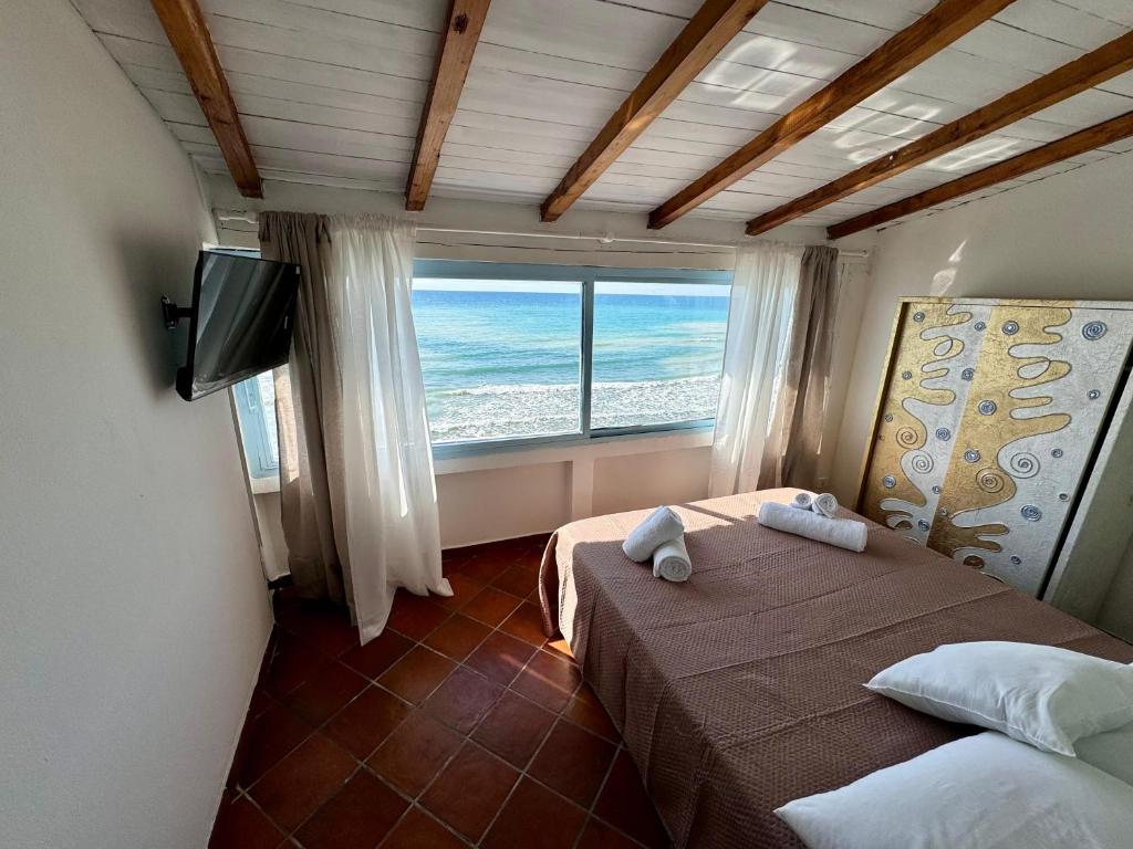 1 dormitorio con 2 camas y ventana grande en Golden Home, en Anzio