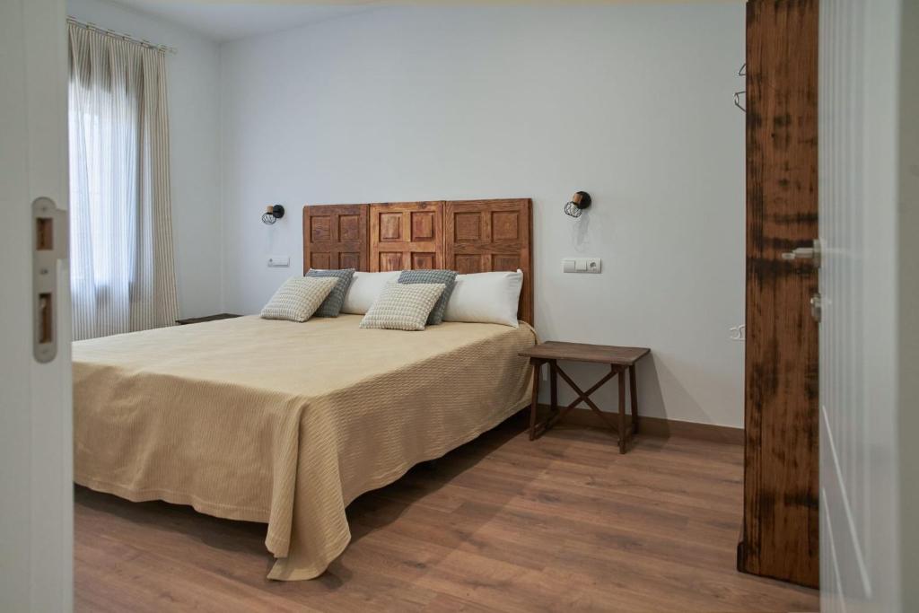 Argés的住宿－Casas rurales El Aljibe, lavanda，一间卧室配有一张大床和木制床头板