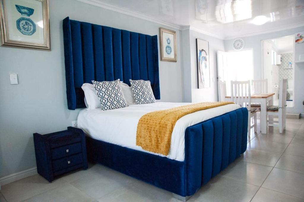 1 cama grande con cabecero azul en un dormitorio en 8 on Deary, en East London