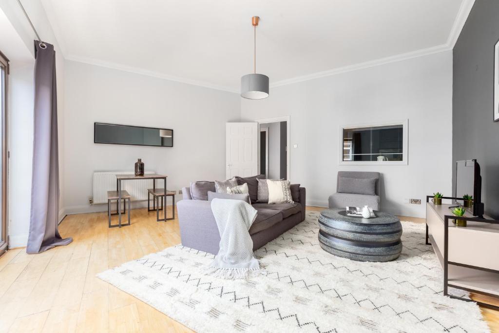 a living room with a couch and a table at The Clerkenwell Flats in Greenford