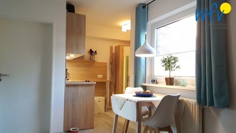 a kitchen with a table and chairs and a window at Haus Colonia - Wohnung 3 in Wangerooge
