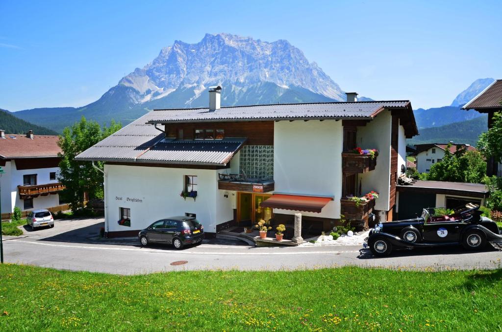 uma casa com um carro estacionado em frente com uma montanha em Haus Bergfrieden em Lermoos