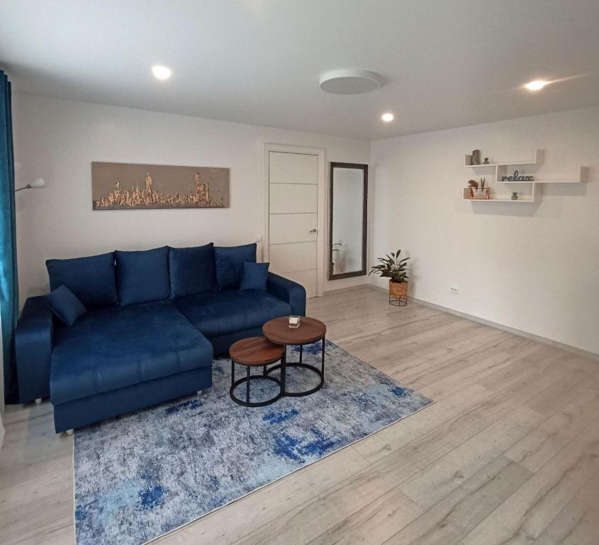 a living room with a blue couch and a table at Vytekstos Apartamentai in Druskininkai