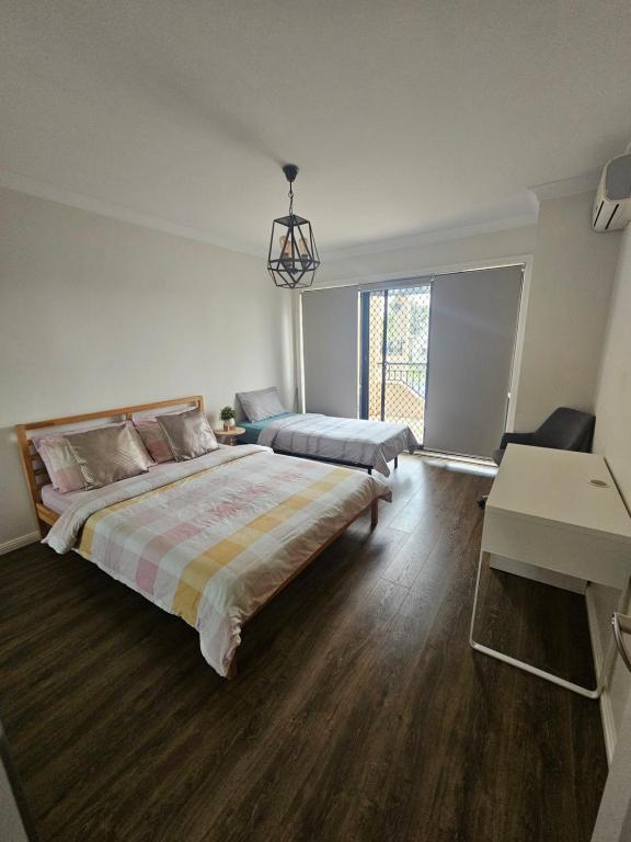 Habitación grande con 2 camas y escritorio. en Book a Room with a view for your stay with shared bathroom laundry kitchen and living area en Guildford