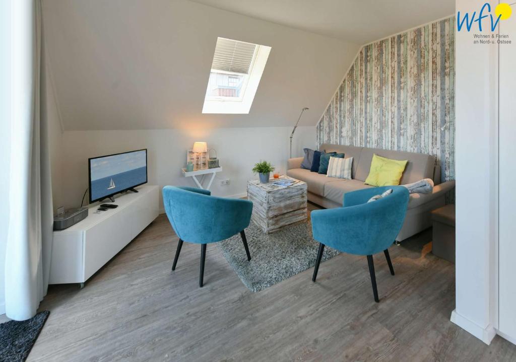 a living room with a couch and a tv at Bootshaus in den Duenen - 4 "Ferienwohnung Duenenkoje" in Wangerooge