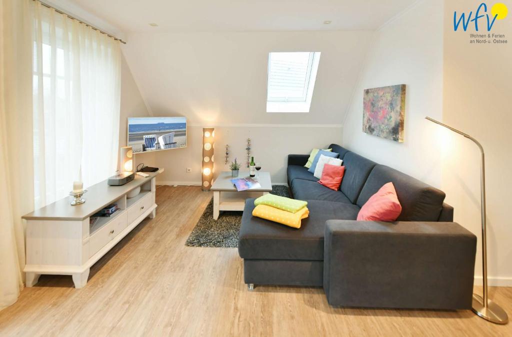 ein Wohnzimmer mit einem Sofa und einem Tisch in der Unterkunft Bootshaus in den Duenen - 4 "Ferienwohnung Sonnendeck" in Wangerooge
