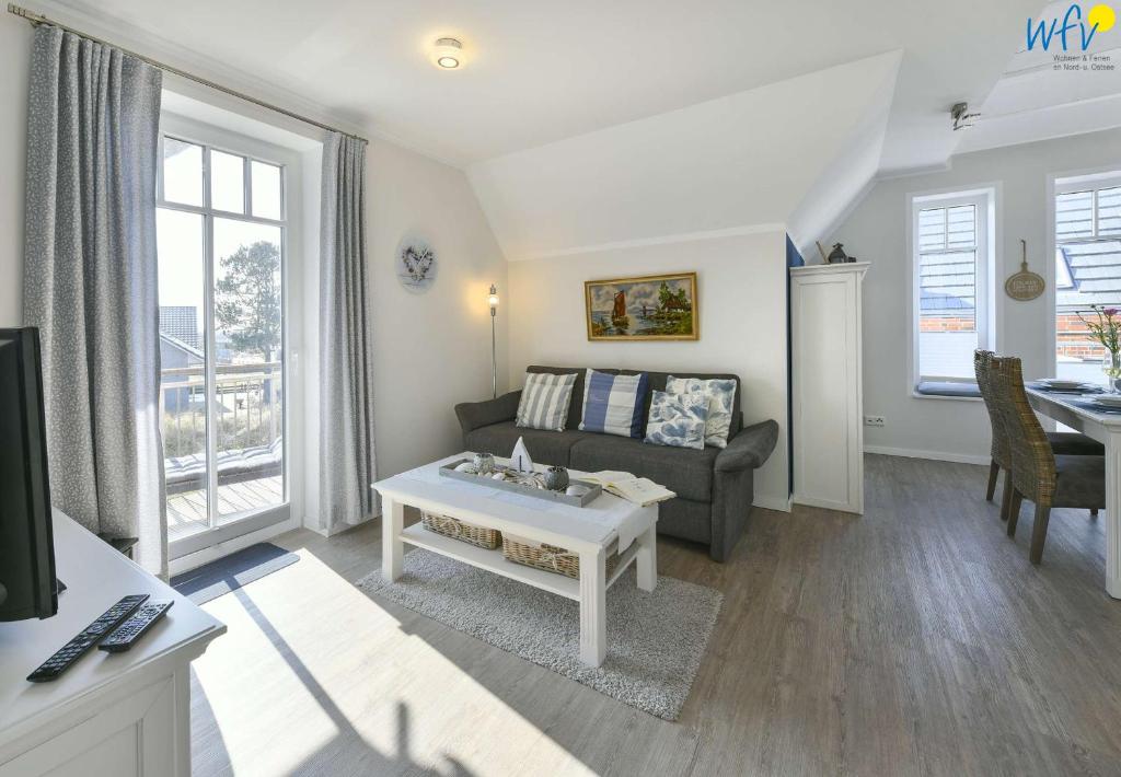 a living room with a couch and a table at Bootshaus in den Dünen Ferienwohnung 4 in Wangerooge