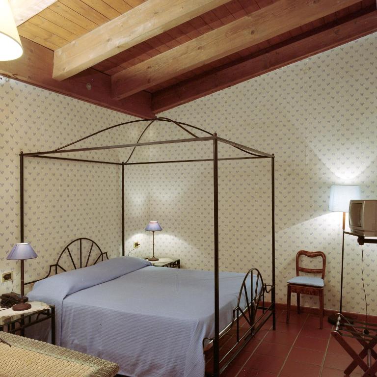 1 dormitorio con 1 cama con dosel de metal en Masseria Mofetta, en Acquaviva delle Fonti