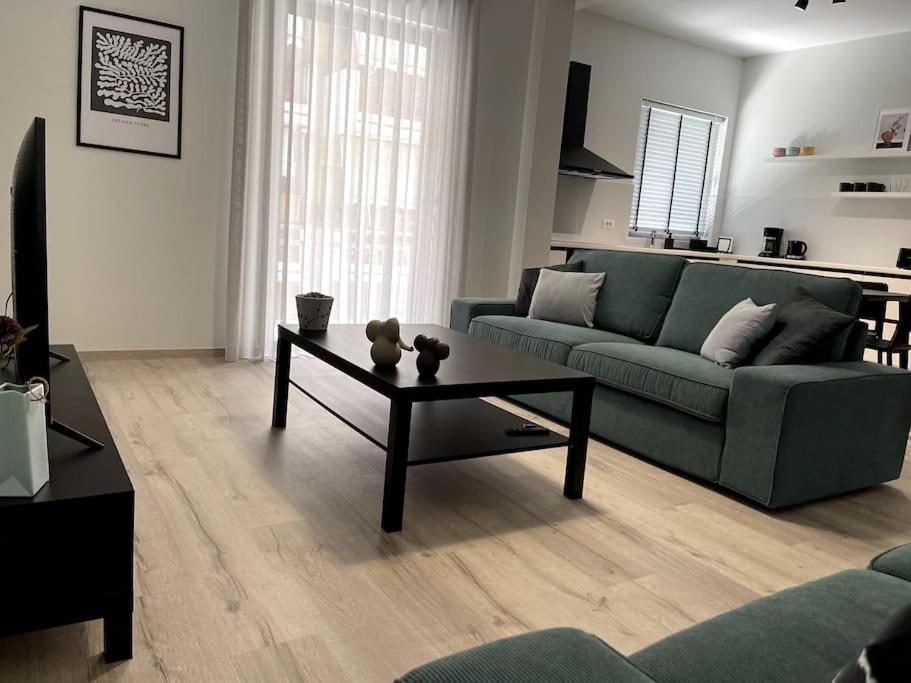 ナフプリオにあるBrand new in-town apartmentのリビングルーム(緑のソファ、コーヒーテーブル付)