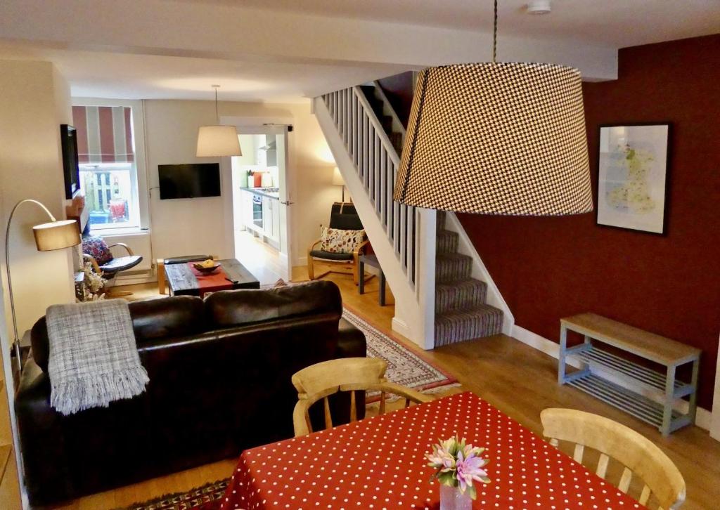 a living room with a couch and a staircase at Chic 2-bedroom townhouse in vibrant Abergavenny in Abergavenny