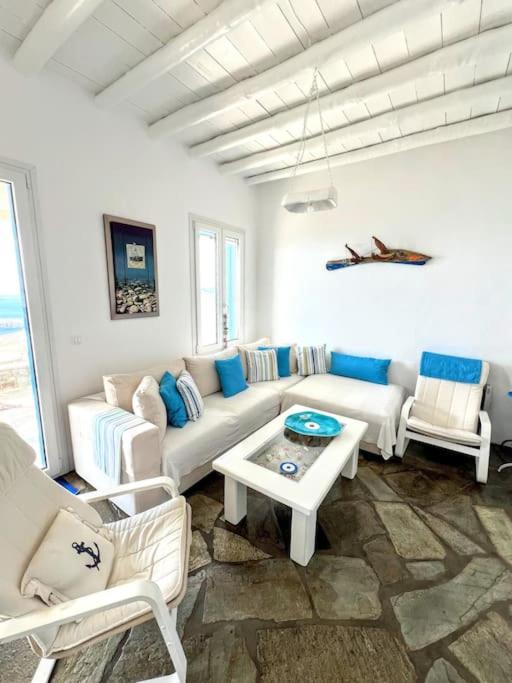 a living room with a couch and chairs and a table at Aggeliki's Cycladic Villa by Hostandros in Batsi