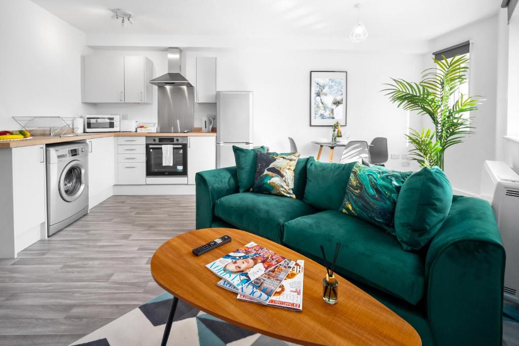 a living room with a green couch and a table at New Modern 2 Bedroom Apartment - WIFI & Netflix - Secure Parking - 27AC in Sleightholme