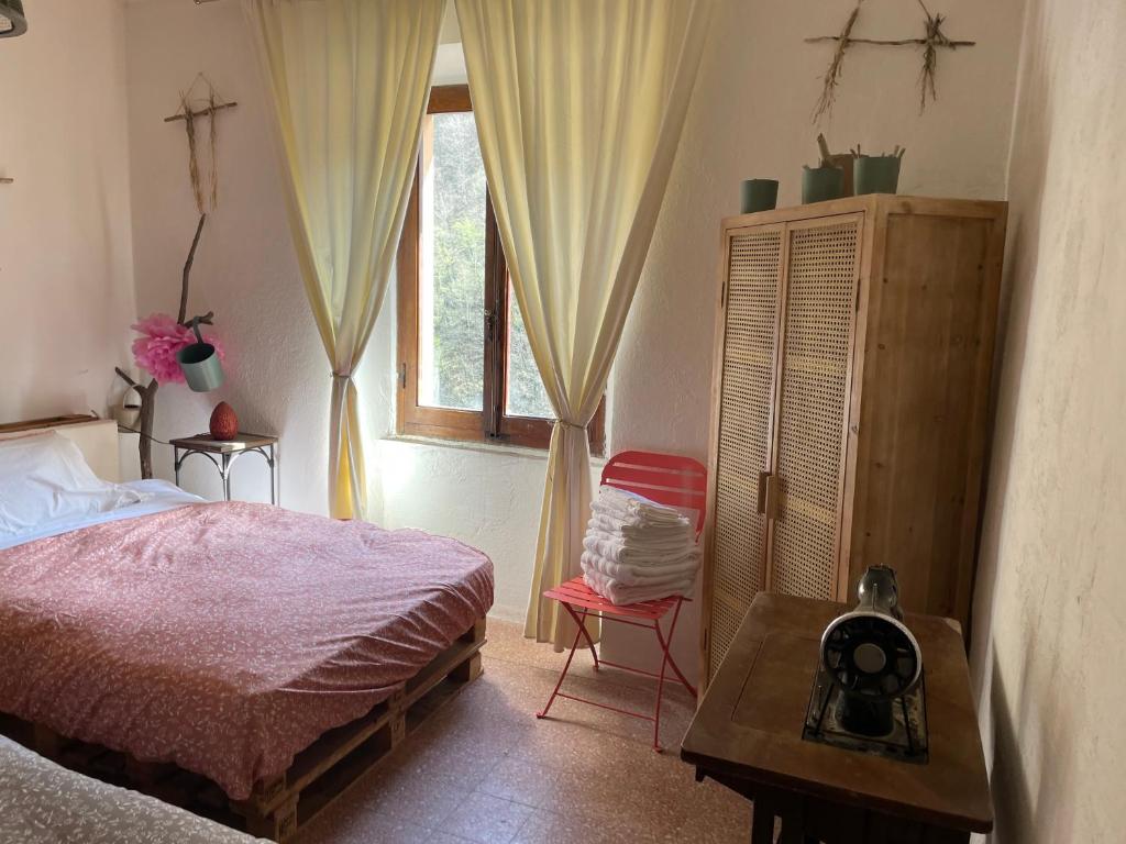 a bedroom with a bed and a window and a table at Casa della Nonna in Porretta Terme