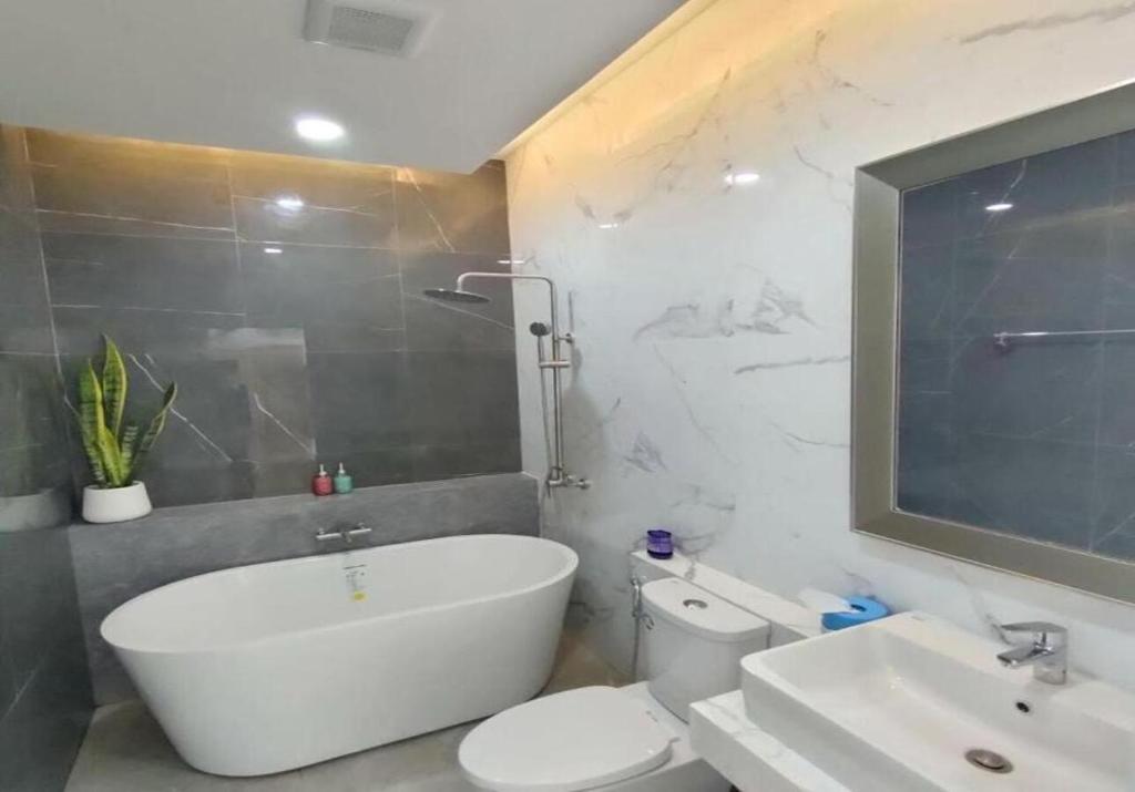 uma casa de banho com uma banheira, um WC e um lavatório. em Pool Villa Udonthani em Udon Thani