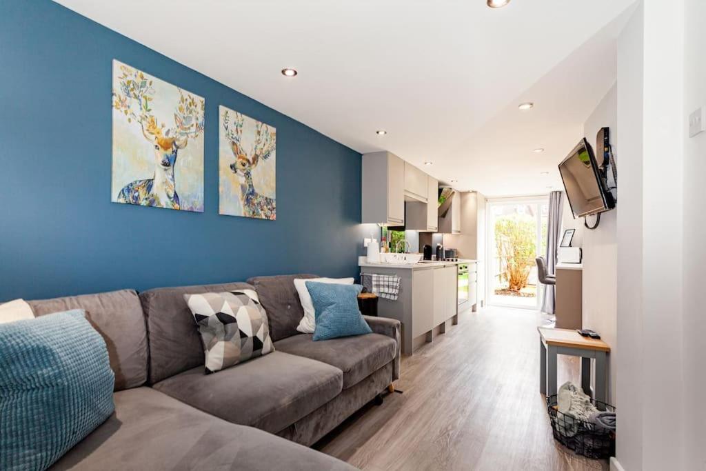 uma sala de estar com um sofá e uma parede azul em One bedroom apartment, Driveway, Bracknell Centre em Bracknell