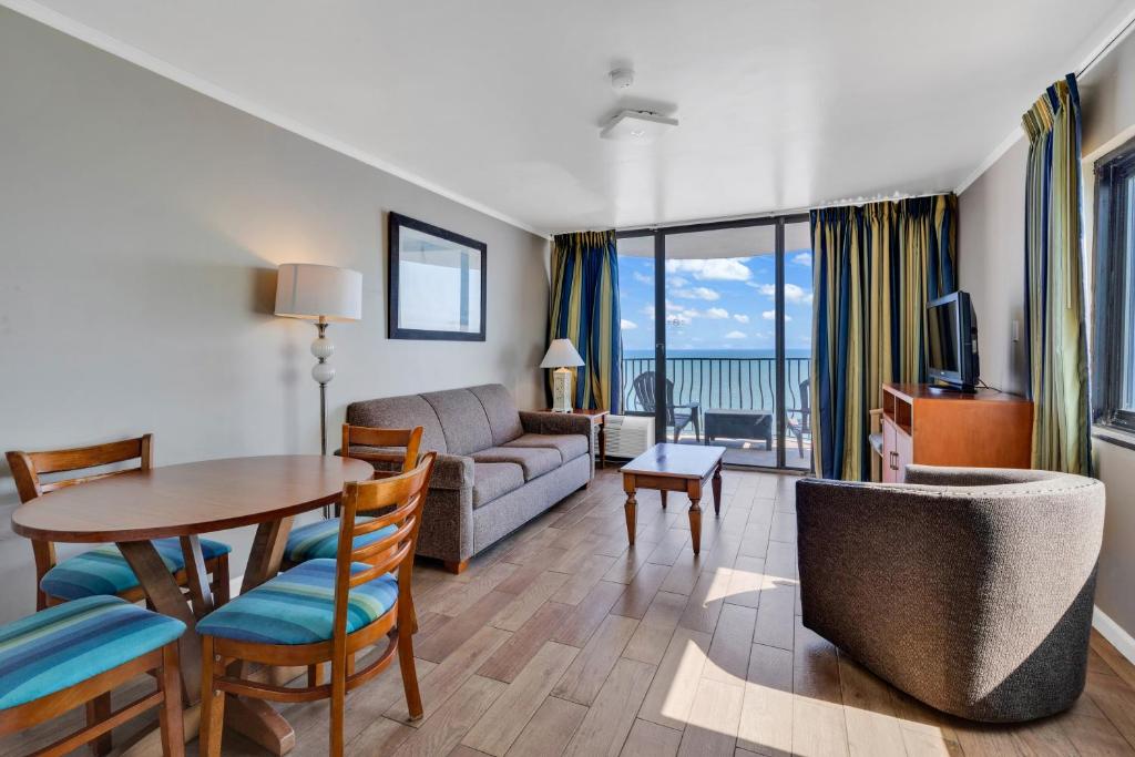 een woonkamer met een bank en een tafel met een eetkamer bij Beachfront Luxury Condo w Private Balcony in Myrtle Beach