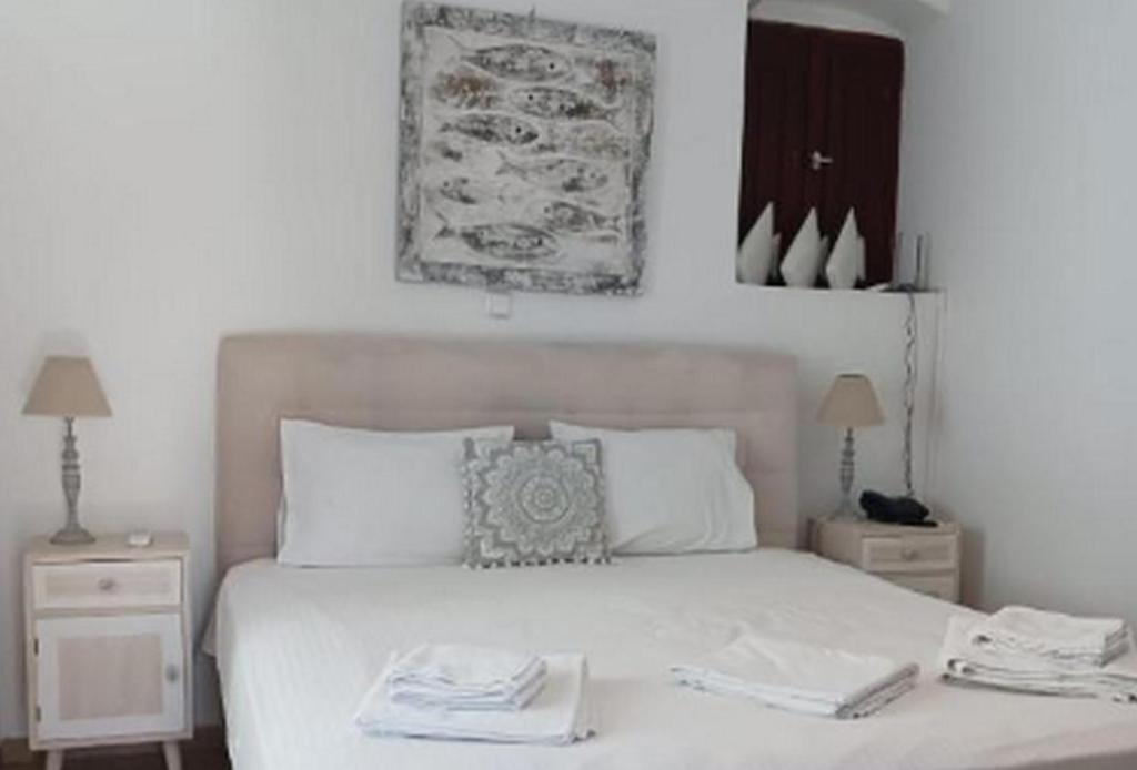 a bedroom with a white bed with two night stands at Beautiful Santorini Villa 1 Bedroom Suite Villa Laxus Pyrgos in Pyrgos