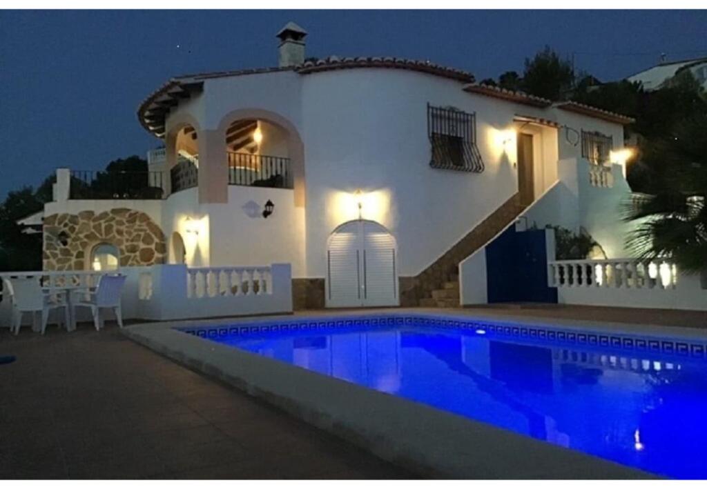 une villa avec une piscine la nuit dans l'établissement Casa Romero, à La Font D´En Carròs