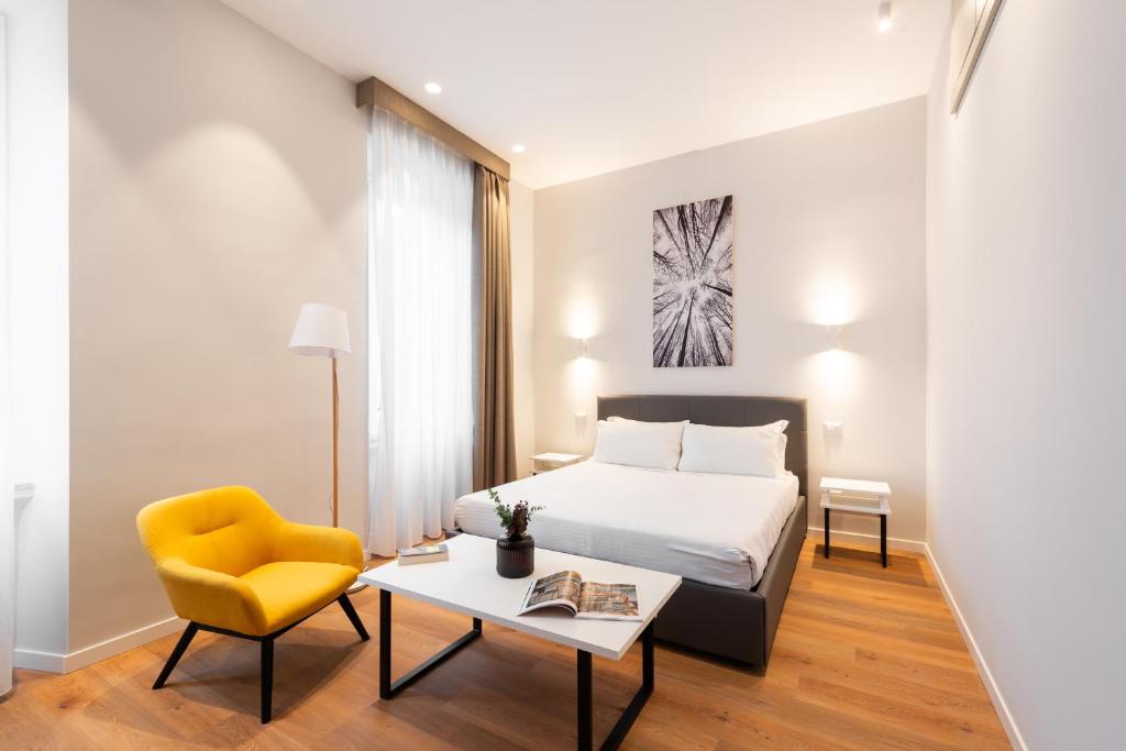 sypialnia z łóżkiem i żółtym krzesłem w obiekcie Major House - Luxury Apartments w Rzymie