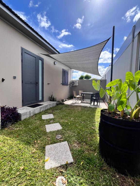 une arrière-cour avec une terrasse dotée d'une table et de chaises dans l'établissement Appartement «Le Ti songe», à Saint-Joseph