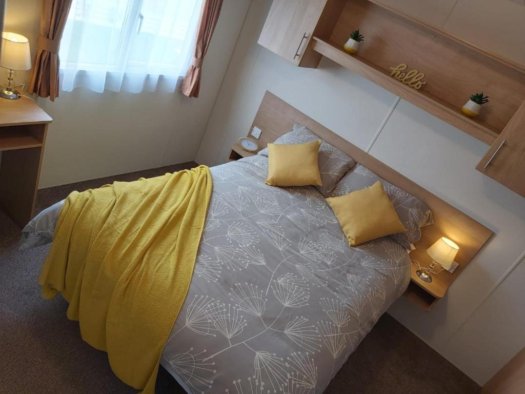 a bedroom with a bed with yellow pillows at Endless Summer in Barnstaple