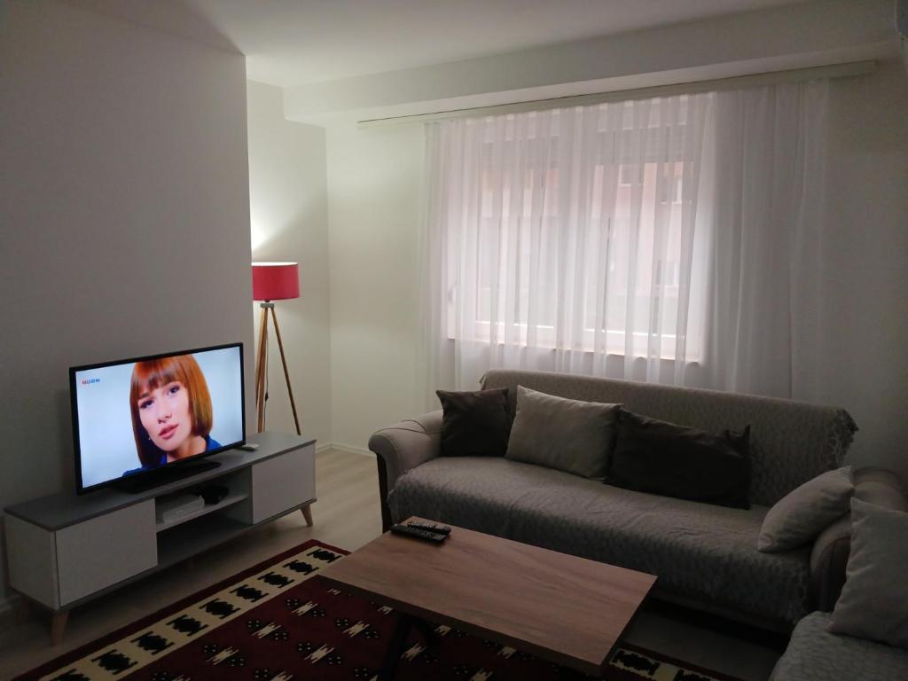ein Wohnzimmer mit einem Sofa und einem TV in der Unterkunft Apartment Dastidi in Kosovo Polje