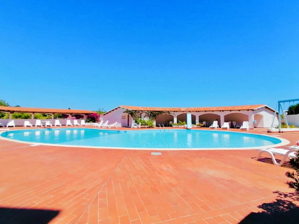 uma piscina num resort com um céu azul em Baja Sardinia Pool Residence em Baja Sardinia