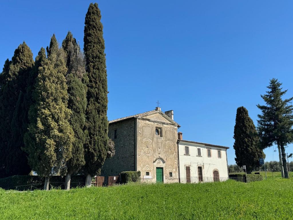 an old house on a hill with trees at Orvieto Country House in Castiglione in Teverina