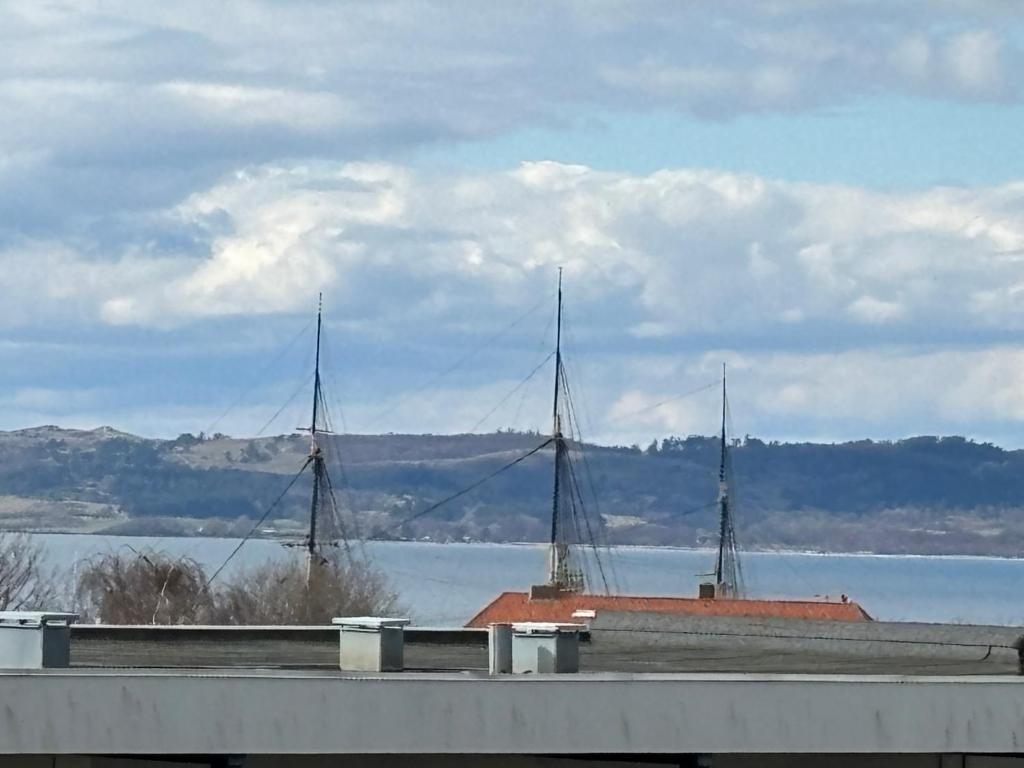 a view of a large body of water with two masts at Udsigten. in Ebeltoft