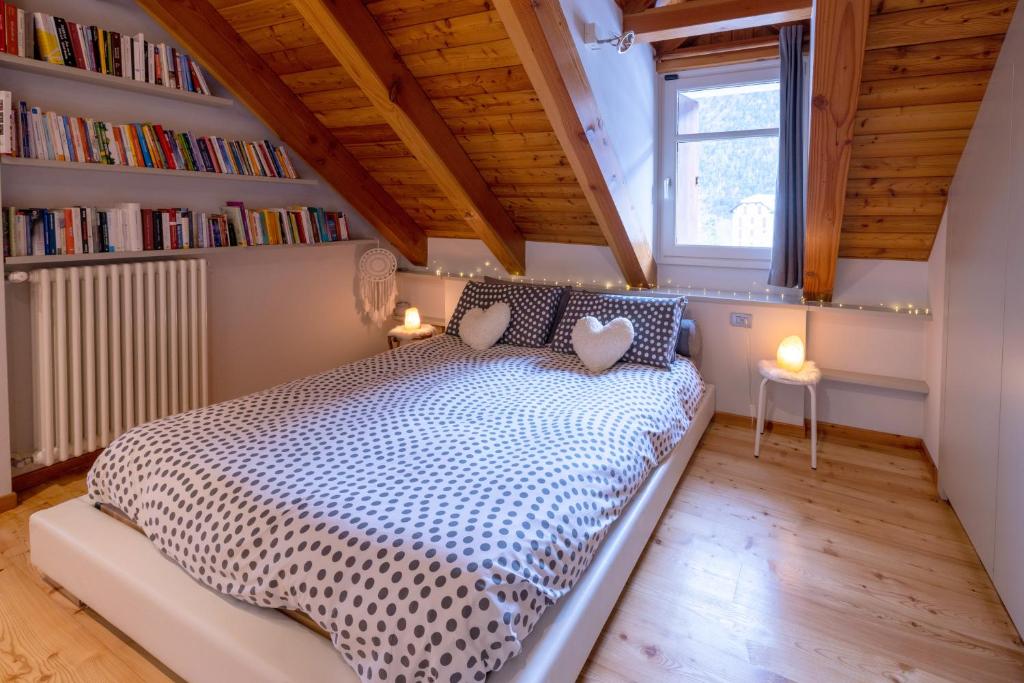 una camera con letto in una stanza con libreria di L'ATTICO DELL'AMORE a Santa Maria Maggiore