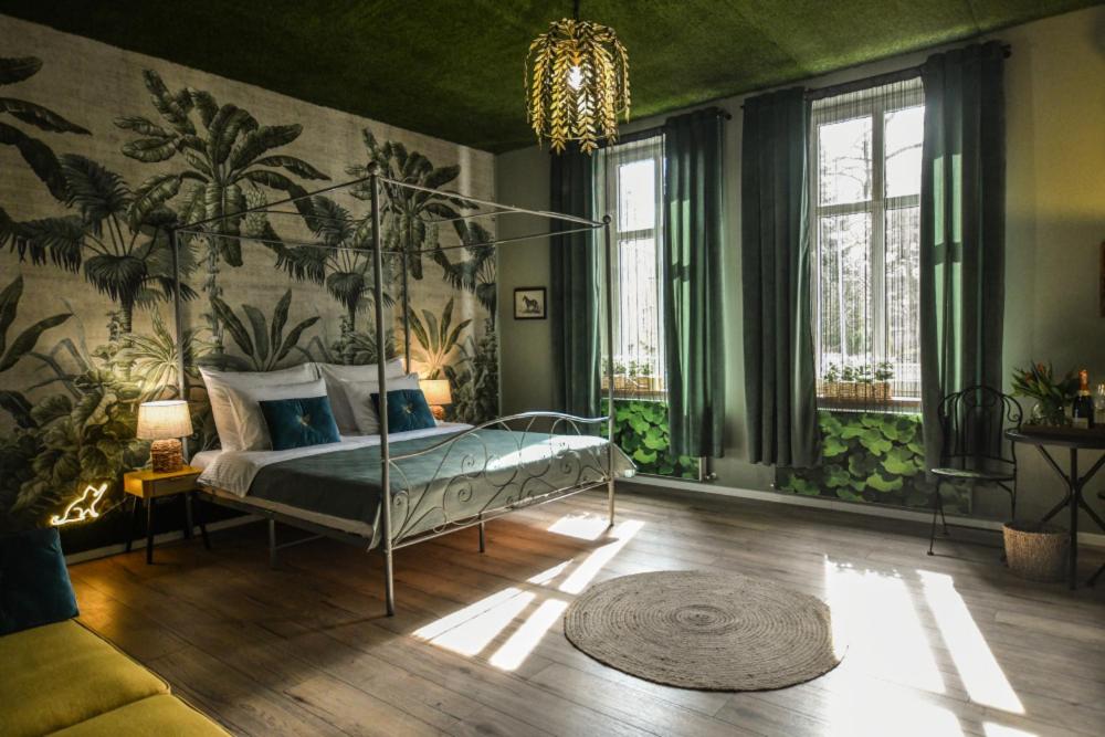 um quarto com uma cama de dossel num quarto com paredes verdes em Apartament Palmiarnia przy Zamkowej w Wałbrzychu em Wałbrzych