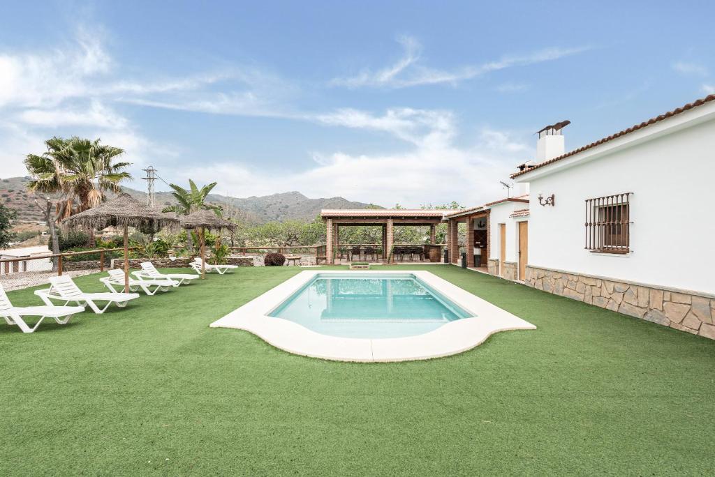 une image d'une arrière-cour avec piscine et pelouse dans l'établissement Finca Llano de Fe, à Malaga