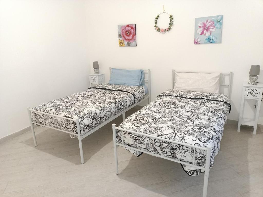 two beds sitting next to each other in a room at Gregorihouseroma in Rome