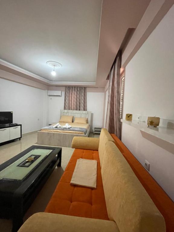 a living room with a couch and a bed at Eveline Boutique Apartments in Sarandë