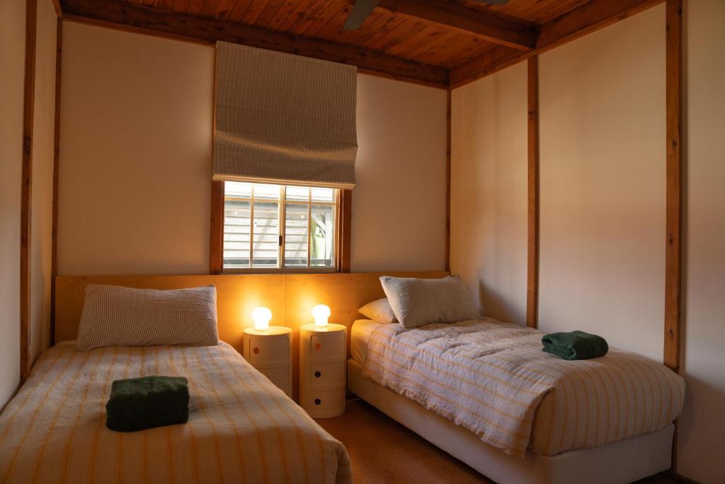 1 dormitorio con 2 camas y ventana en Seahorse Manor, The South Coast Sandcastles, en Huskisson