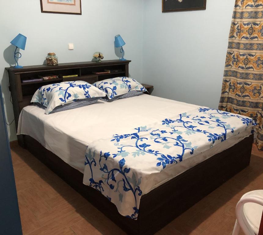 a bedroom with a bed with blue and white sheets at Villa Evenik in Eretria