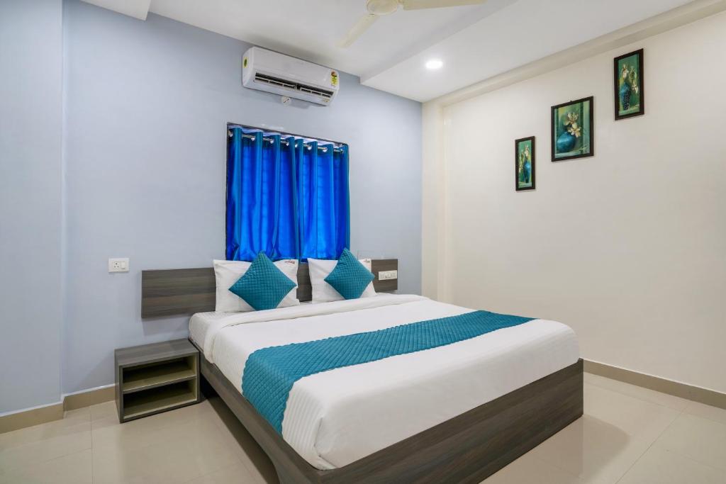 a bedroom with a large bed with a blue curtain at The Balcony Suites in Hyderabad