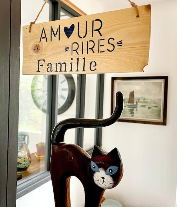 un chat noir assis dans une chaise devant une fenêtre dans l'établissement l'amour, le rire et la famille, à Hillion