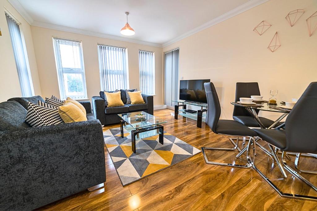 een woonkamer met een bank en een tafel bij Heathrow RARE find 2 Bedroom plus 2 Bathroom flat - Sleeps 6- Free Parking- Close to Heathrow Terminals-Quiet development in Stanwell