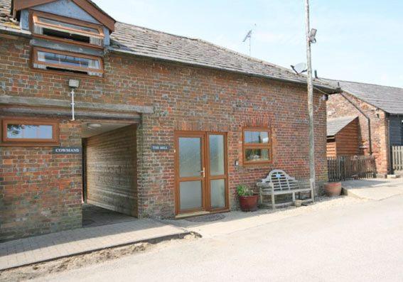 a brick building with a garage and a door at The Mill in Leighton Buzzard