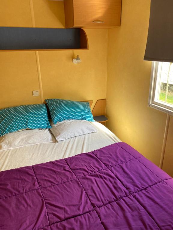 - une chambre avec un lit violet et une fenêtre dans l'établissement Mobil Home 5 personnes - Camping *** Les Ollivaud-, à La Baule