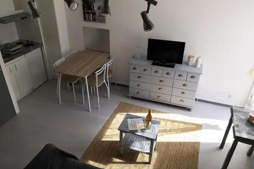 a living room with a tv and a table and a tableablish at Appartement proche de la plage des minimes in La Rochelle