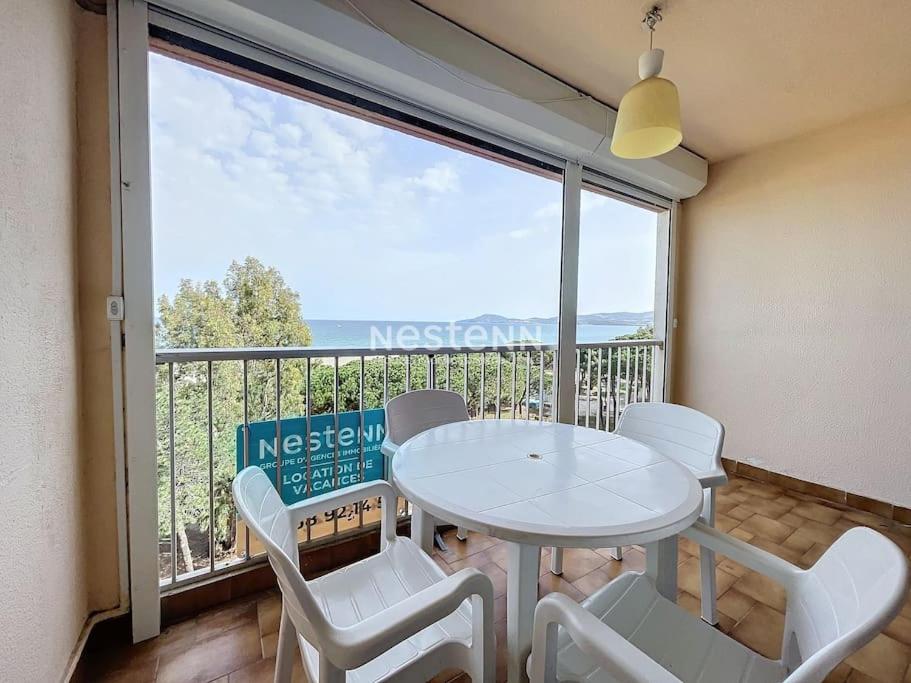 une pièce avec une table et des chaises et une grande fenêtre dans l'établissement 3206-T2 première ligne vue mer, à Argelès-sur-Mer