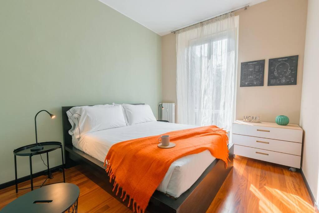 Un dormitorio con una cama con una manta naranja. en Loft Sterlizia, by R Collection Apartment, en Milán