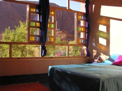 ein Schlafzimmer mit einem Bett und einem großen Fenster in der Unterkunft Guest house Amande in Tinghir