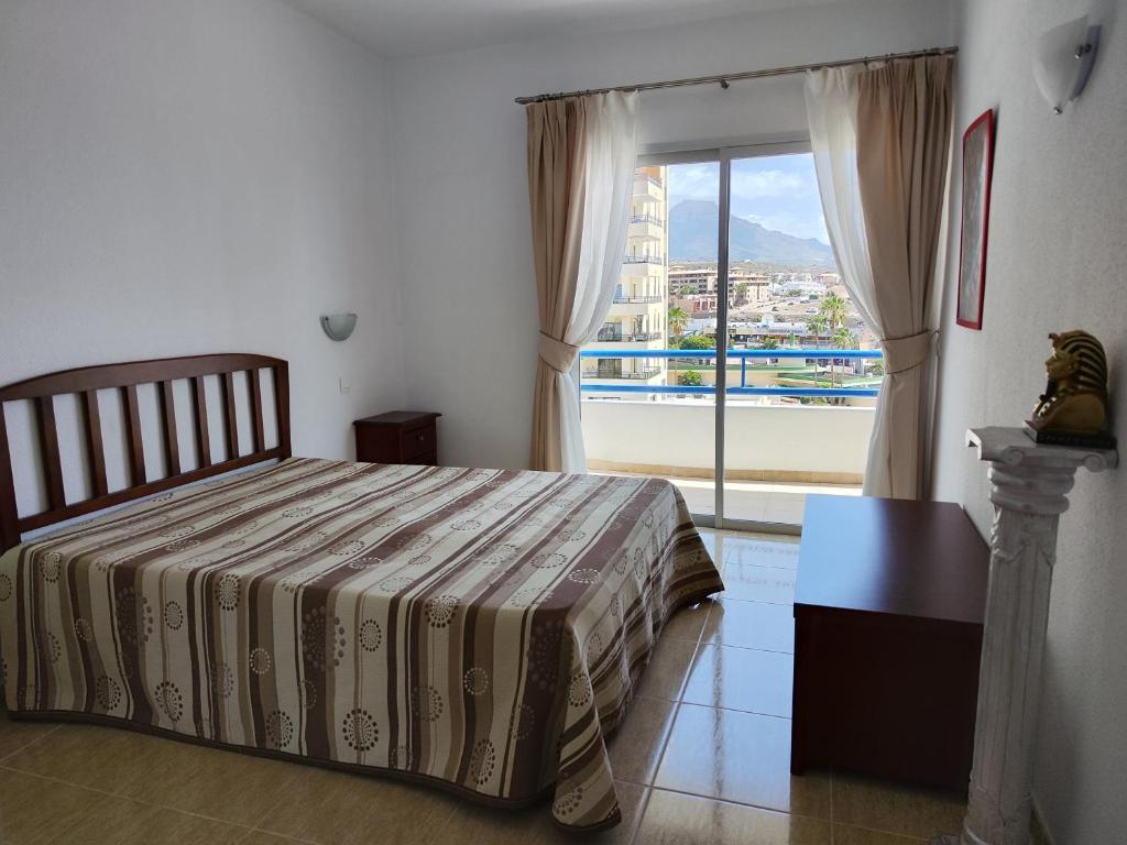 a bedroom with a bed and a large window at Olga Paraiso del Sur in Playa Paraiso