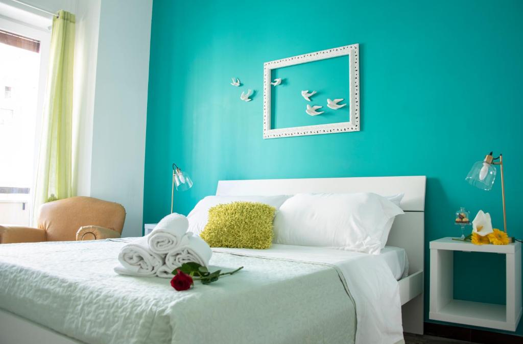 1 dormitorio con paredes azules y 1 cama con sábanas blancas en Reginella Guest House, en Salerno